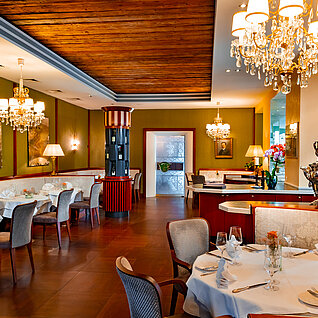 Elegantes Gourmetrestaurant mit Kronleuchtern und ordentlich gedeckten Tischen
